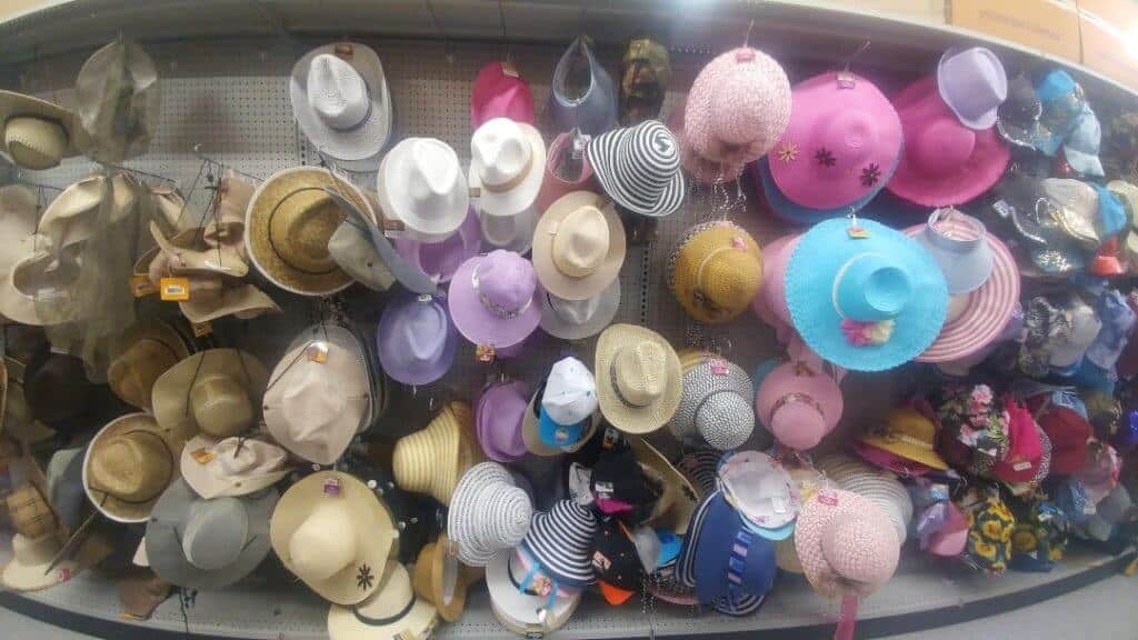Different sunhats in an aisle, travel essentials to buy at the Dollar Store