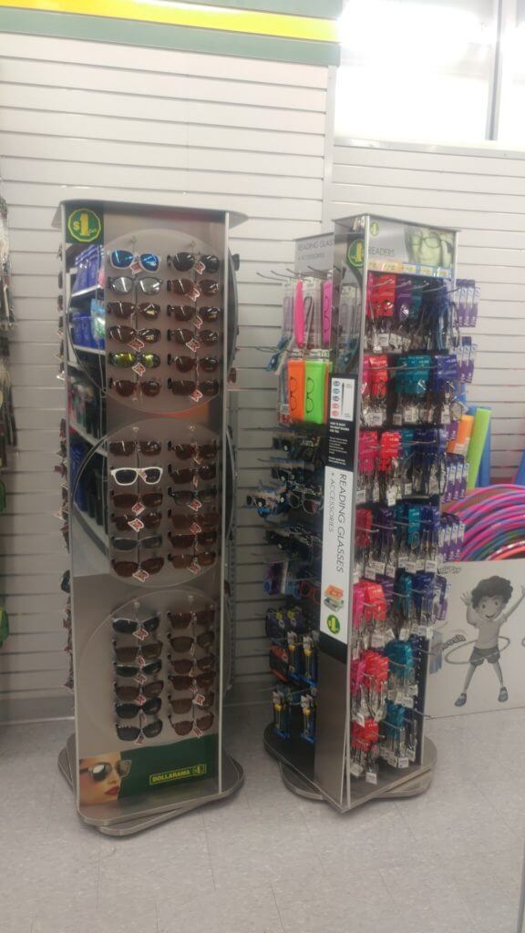 Two racks of sunglasses and reading glasses, travel essentials to buy at the Dollar Store