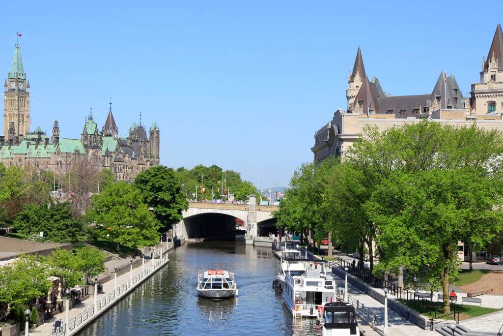 View of the Rideau Canal with the Château Laurier to the right and Parliament Hill to the left