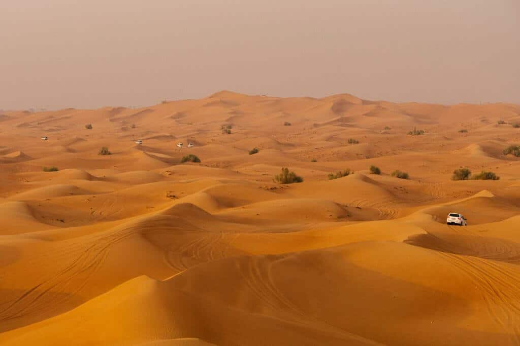 A vast desert with dunes, 4x4 jeeps 