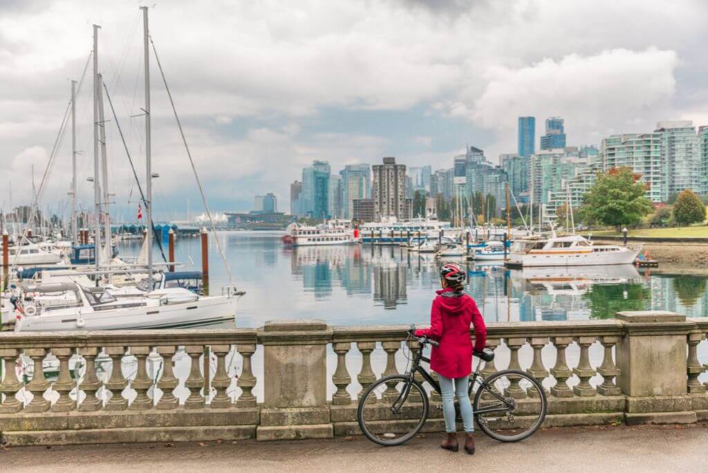 Rent bike Stanley Park, girl with a red coat with a bike