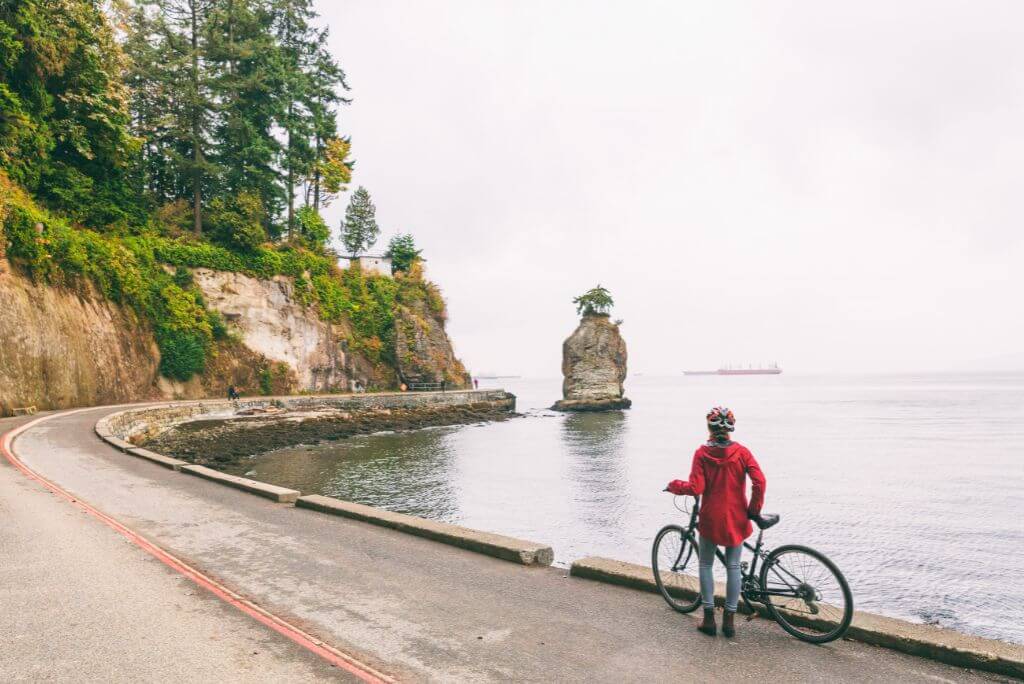 Bike rentals in Stanley Park - Pineapple Rock, girl with a red coat and a bike