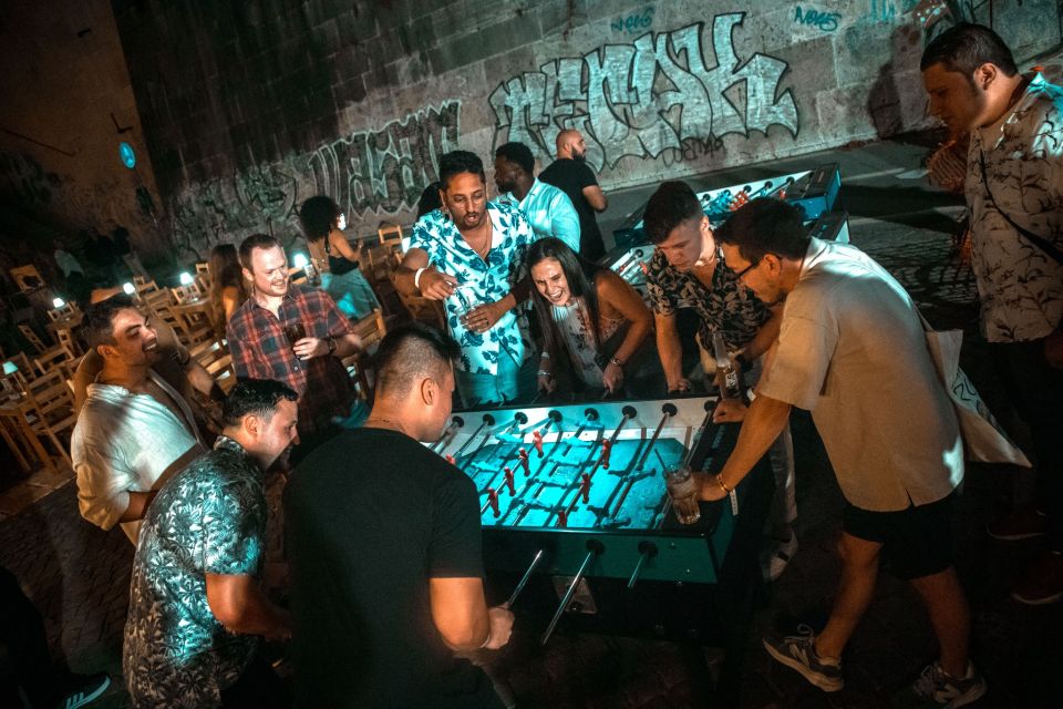Party games during the pub crawl, a group of people playing foosball
