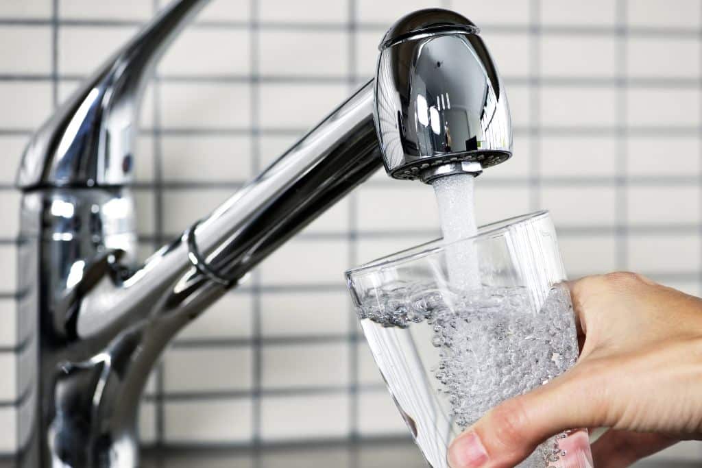 person filling up a glass of water, tap, faucet, sink