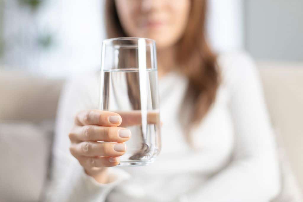 woman holding a glass of water, drinking water, glass