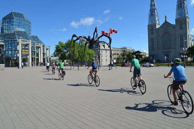 A group of tourists doing a bike tour beside the National Gallery of Canada