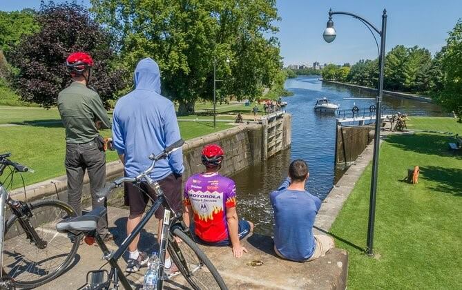 A group of men sitting and enjoying Rideau Canal in Ottawa, Ottawa bicycle tours 