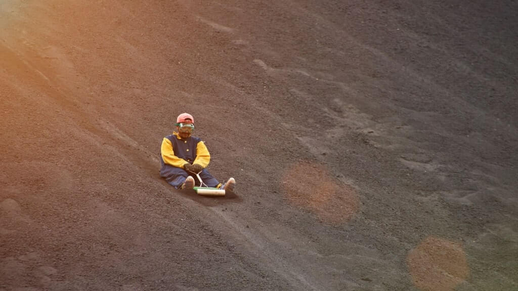 A person volcano boarding, León, Nicaragua