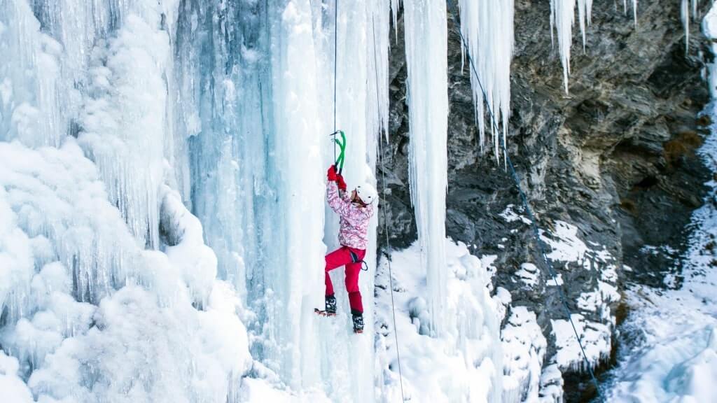 A woman ice climbing, frozen waterfalls