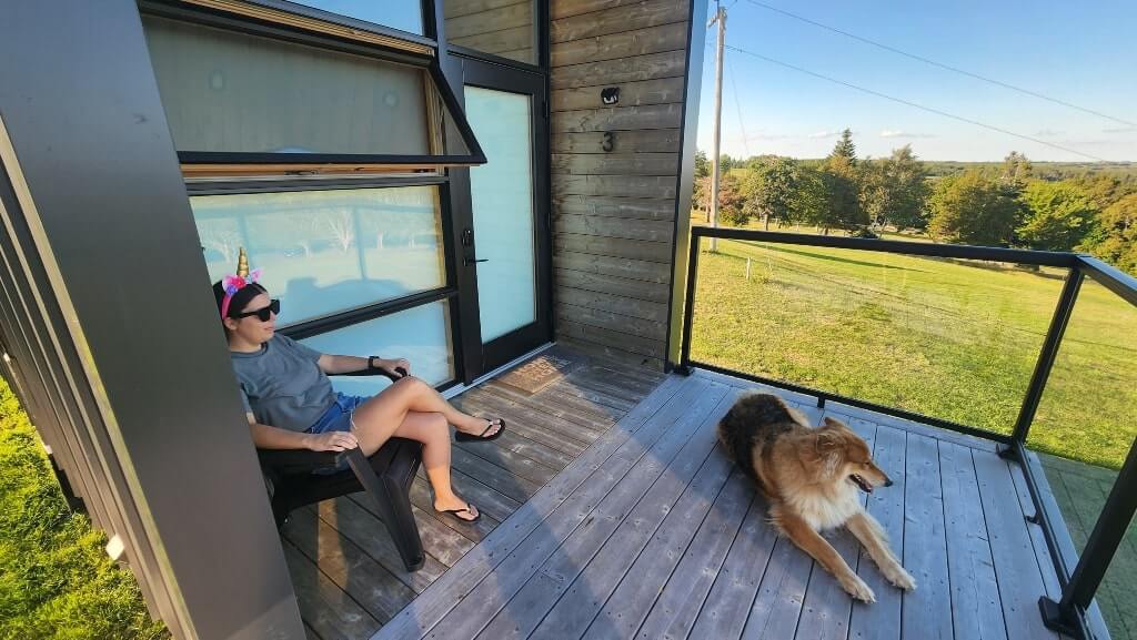 A girl and a dog sitting on a porch, glamping, relaxing