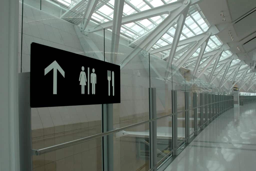 A washroom sign in an airport, making a quick bathroom stop right after security is a great idea