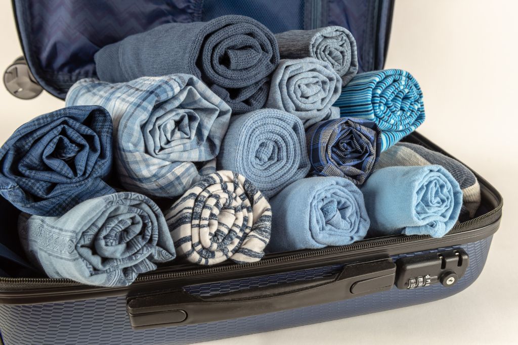 A bunch of clothes in a luggage, they are all rolled up tightly, to become an expert at carry on only travel, you should roll up your clothes tightly
