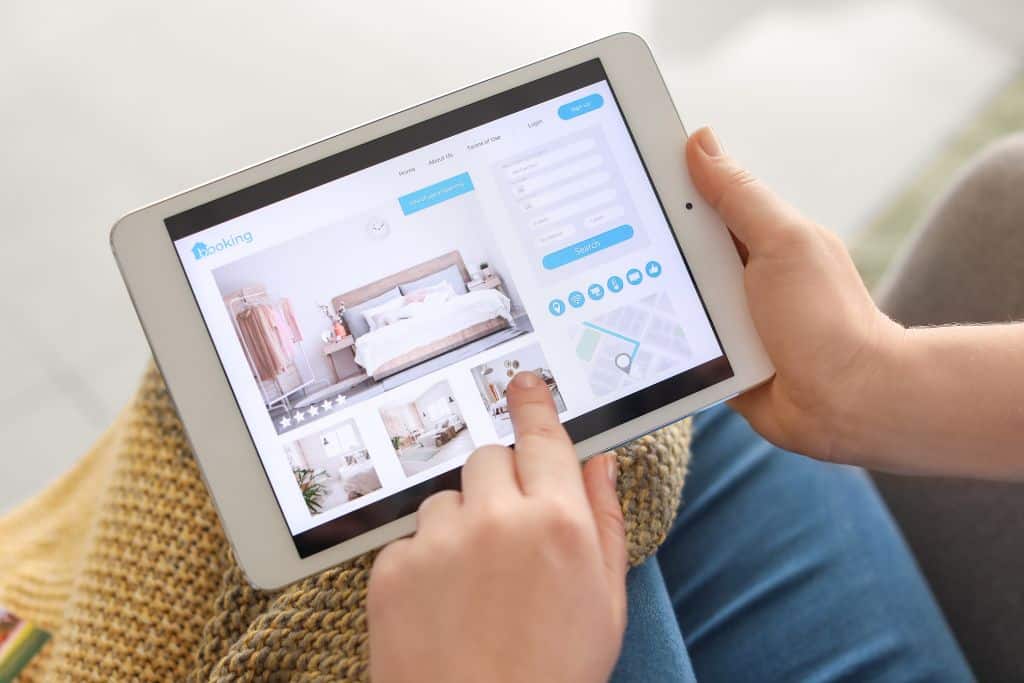 A close up of a white tablet which has a website opened on a hotel booking website