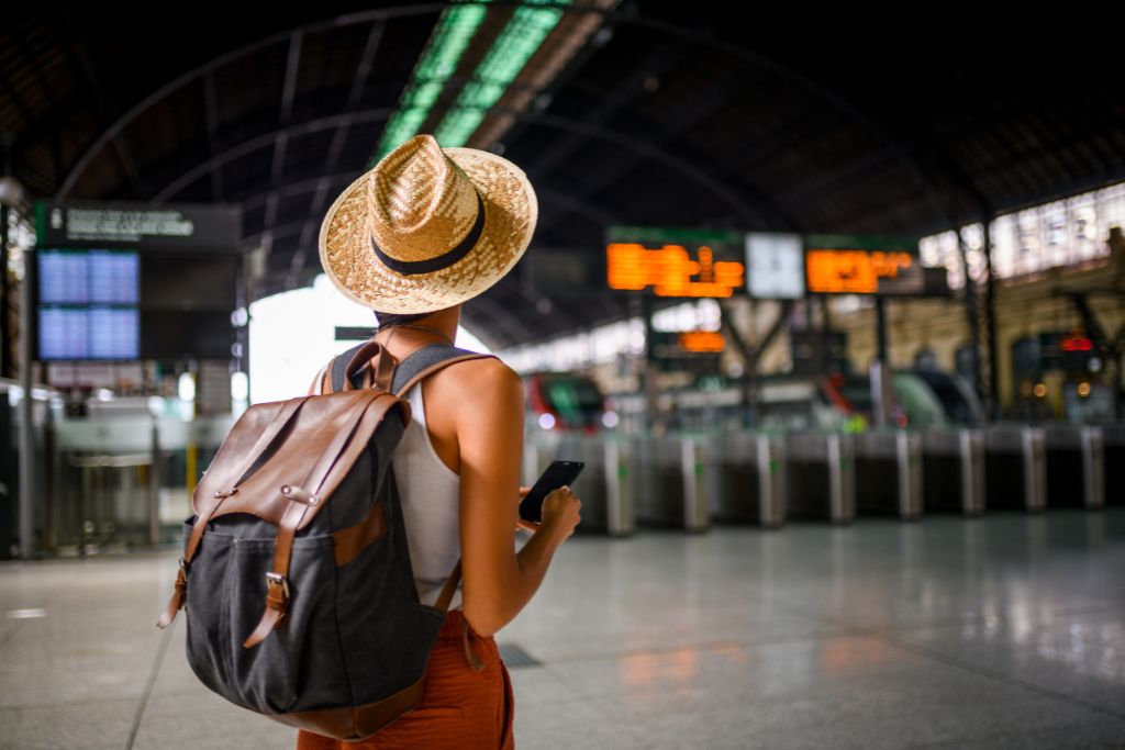 A solo female traveler in a metro or train station, one of the first solo trip safety tips is to always follow your gut
