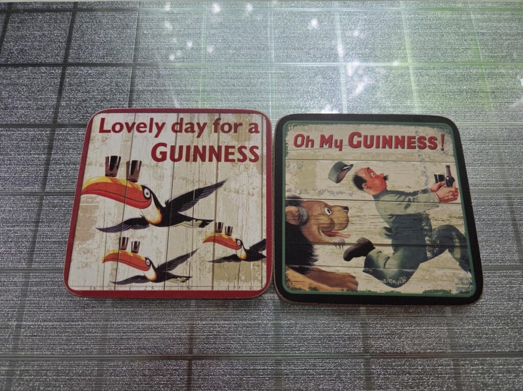 Two coasters from the Guinness Storehouse in Dublin, one of the souvenir ideas to collect from your travels is coasters
