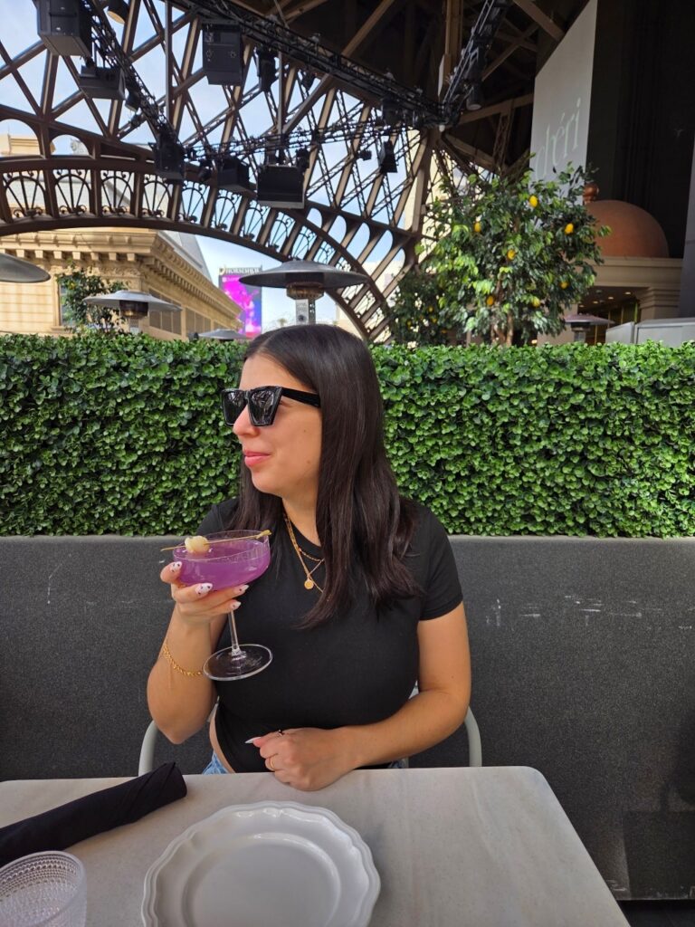 A girl enjoying a cocktail at Cheri Rooftop restaurant in Paris Hotel