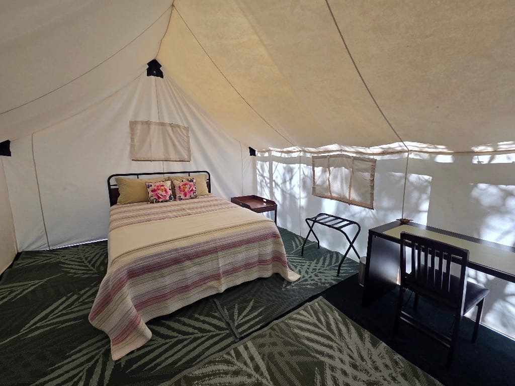 The inside of the Rainbow Haven (Safari Tent), bed inside a tent