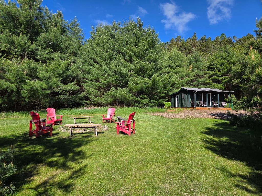 The fire pit is beside the Havens’ Hub, Muskoka chairs
