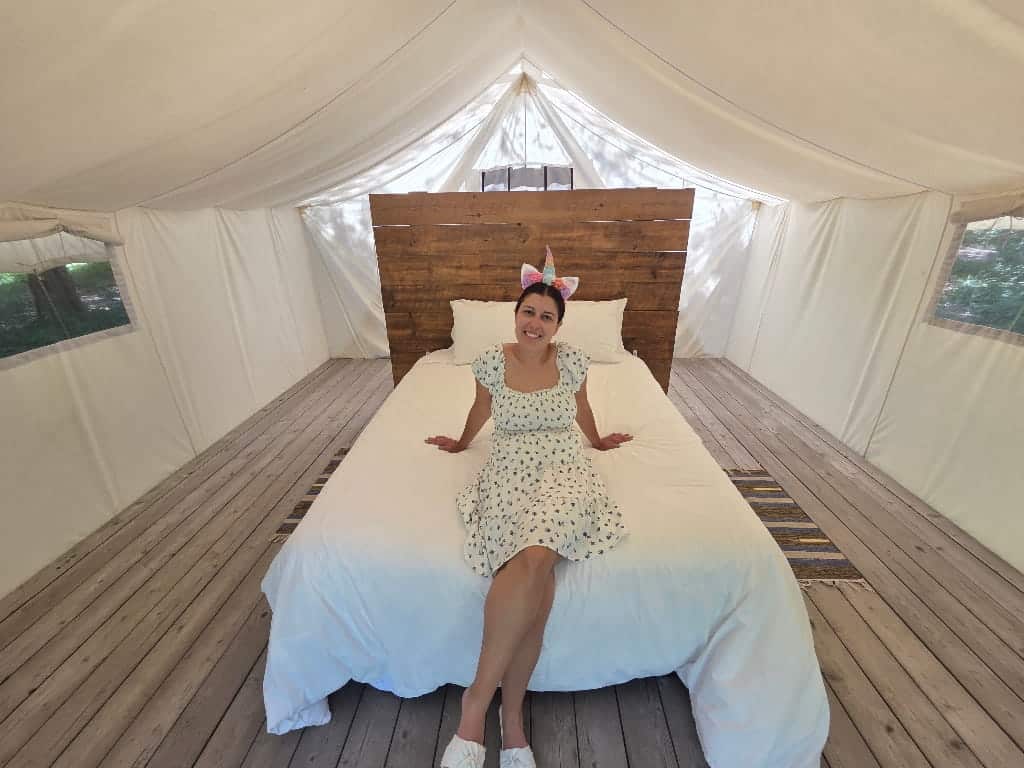 A girl on a bed in a tent, glamping