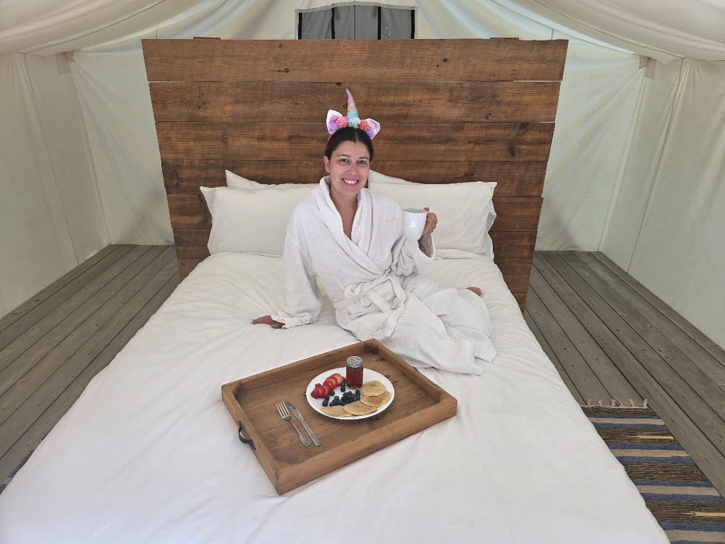 Enjoying our breakfast in bed, a girl in a robe with a tray with breakfast