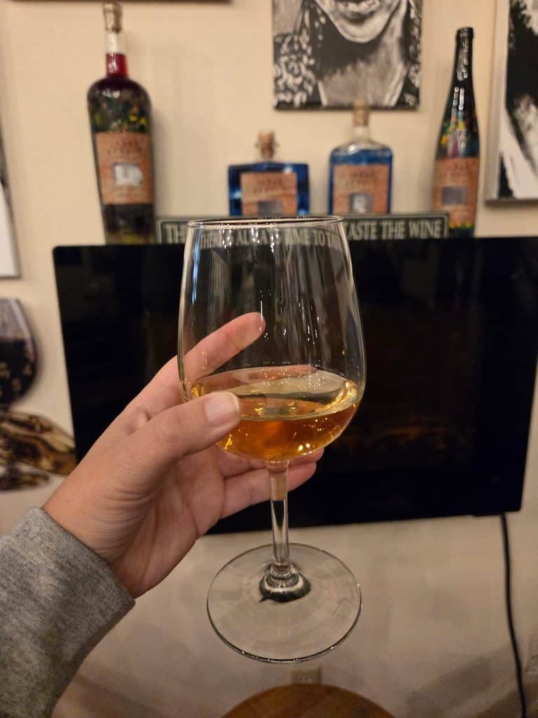 A hand holding a wine glass with white wine and tequila mix, How To Spend Two Days In Minot, North Dakota?